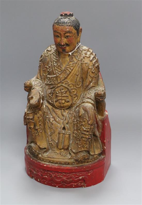 A carved wooden deity with polychrome and gilt decoration height 37cm